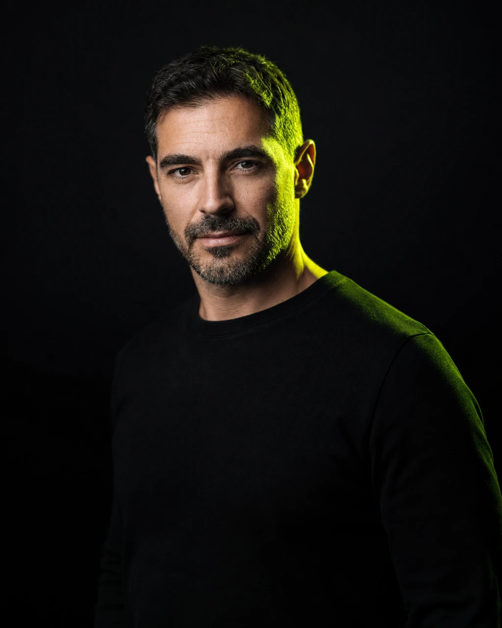 Retrato de un formador sobre fondo negro carbón, iluminado con un perfil de luz lima